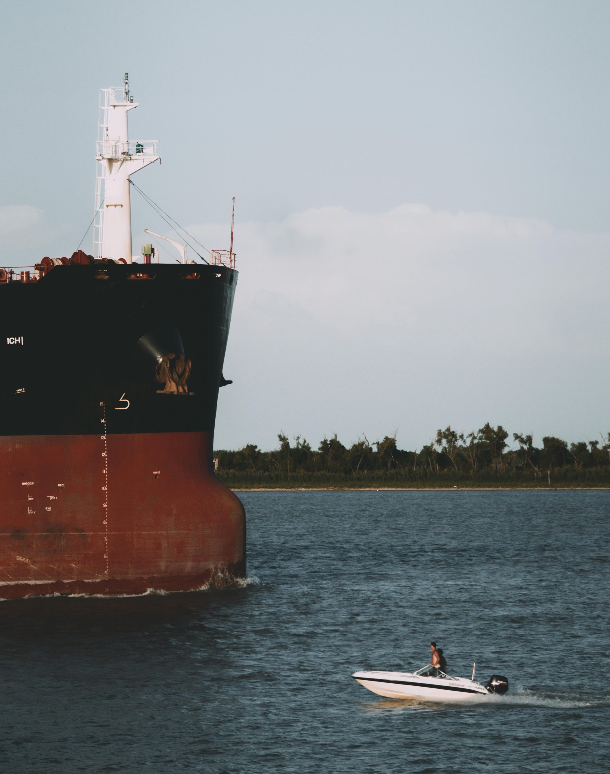 A speedboat navigates beside a large cargo ship on the Parana River in Rosario, Argentina.